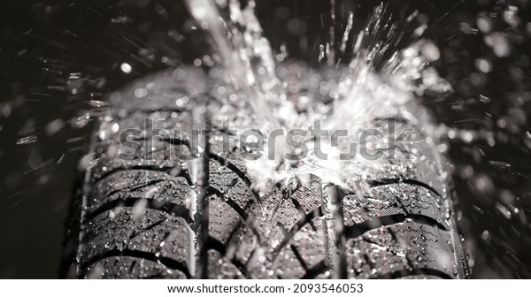 Water splashing on new\
car tyre closeup
