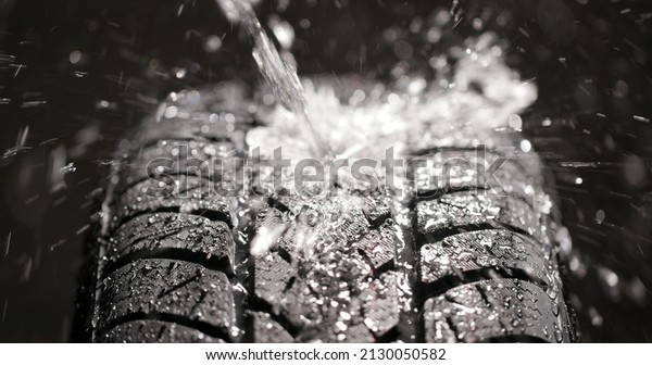 Water splashing on new\
car tyre close up