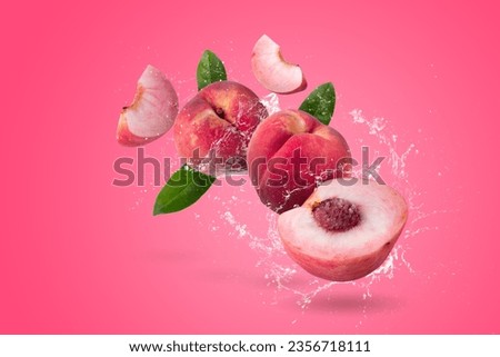 Water splashing on Peach and Peach slice isolater on a pink background
