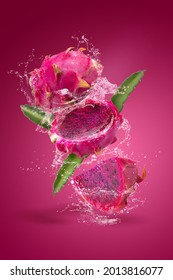 Water splashing on Ripe pitahaya fruit or dragon fruit with half isolated on red background