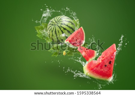 Water splashing on Sliced of watermelon on green background.