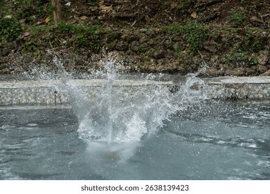 Water Splashing In A Stone Pool, Gray And Green Natural Background