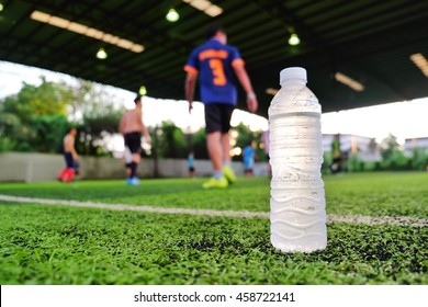 Water sport drink against blurred soccer background on green artificial grass - Powered by Shutterstock