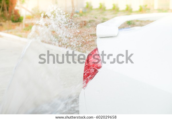 Water spray cleaning car\
body.