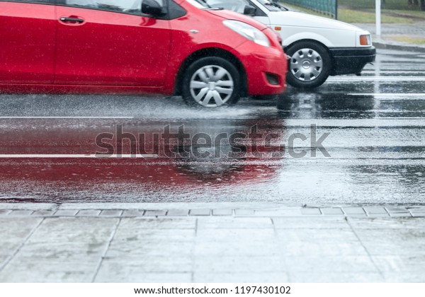 water sprays from car wheels. car traffic during\
rush hours. rainy weather