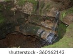 A water spring emerging from a cave and cascading down the rocks and into the ground below.  Namesake of Sinking Spring Farm where President Abraham Lincoln was born in Kentucky.