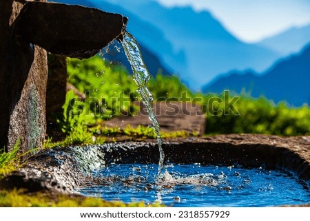 Water spring on Alps mountains background