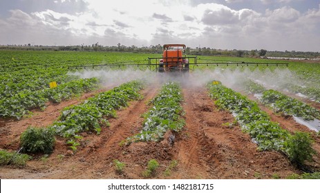 Water sprinkler equipment in India. Tractor irrigating land in Indian agriculture Farmland