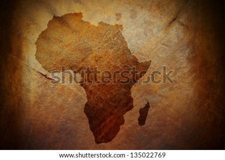 Water stain mark in the shape of the Africa continent map on a weathered brown leather parchment.