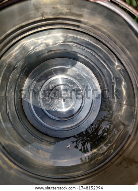 The water in the stainless steel water\
pail.Abstract texture\
background.
