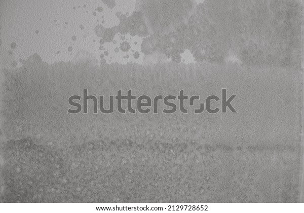 Water stains from a leak above show in a ceiling\
with mottled texture on sheetrock, an interesting rough and grungy\
background texture.