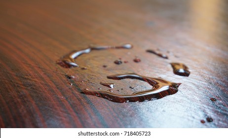 Water stains look like a ring on a desk surface with a pattern resembling wood.