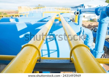 Water steel pipe over blue tank close up image. Select focus of drink water piping. Flange Pipe Fitting. Pipe line guide line.