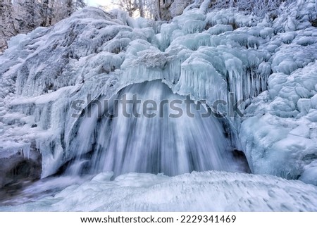 Water still flows behind the frozen waterfall