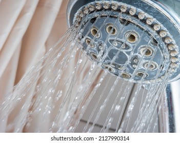 Water Streaming Out Of Silver Round Shower Head Inside Bathroom. Low Angle Close Up Shot, No People.