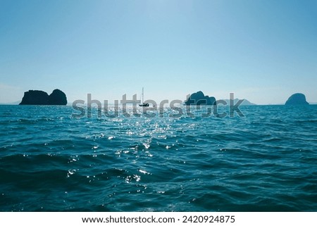 Water sun flare wallpaper close-up background texture. Sparkling sunlight on oceanic waves. Scintillate sea surface and evening summer rocky coastline.