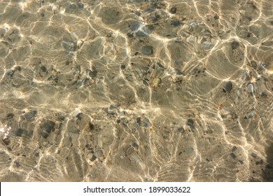 The Water Surface Is So Clear That You Can See Through And See The Rocks Below.