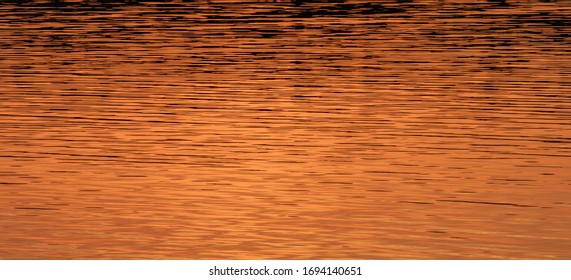 Water surface with reflection of the setting sun. Natural texture.
