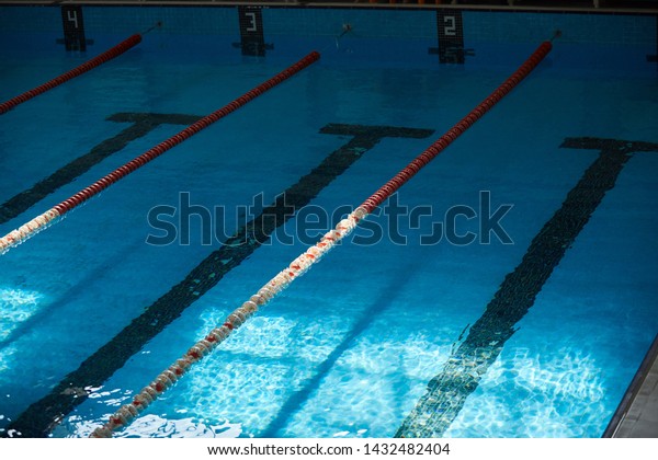 Water surface in the
sports swimming pool. Blue water and swim lane dividers. Sports and
health concept.