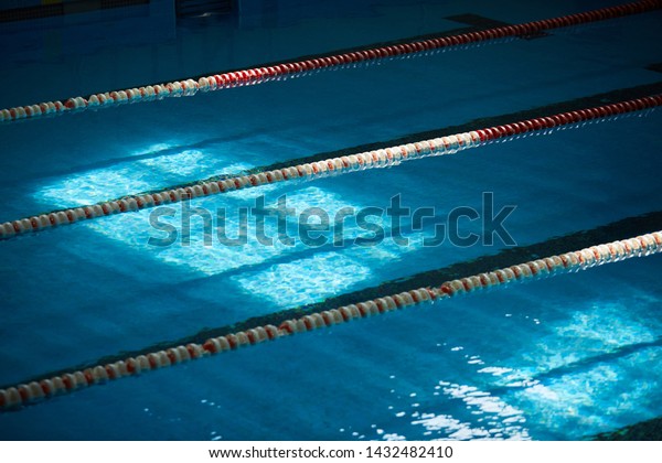 Water surface in the
sports swimming pool. Blue water and swim lane dividers. Sports and
health concept.