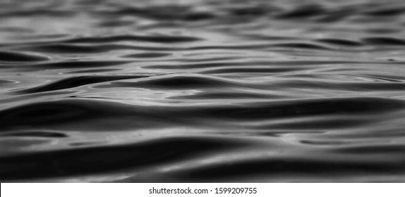 Water Surface Texture - Abstract Art Background In Black And White. Ripple On The Surface Of The Wate. Black And White Water Closeup. Dark Background Of Water Surface. Texture Ripples Lake. Lake Water