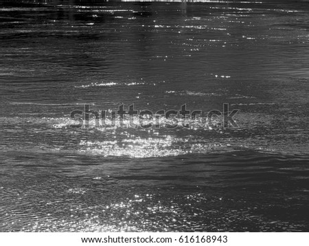water surface with waves and light reflection on a river