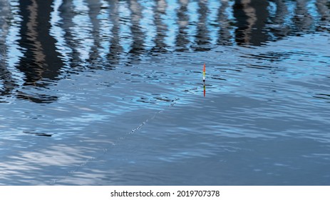 The Water Surface With Waves, Ripples, Splashes And Bubbles. Abstract Natural Background. Fishing Bobber On The Surface Of The Water. Selective Focus.