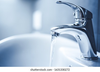 Water tap , faucet. Flow water in bathroom with sink. Modern clean house. Backround hygiene.