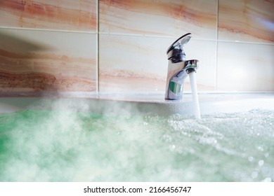 Water Tap Pouring Hot Water In A Bath Tub With Steam