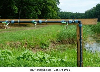 Water taps or faucets in the row. Wooden support. Installation of water supply. Tourists place in the forest. - Shutterstock ID 2364761911
