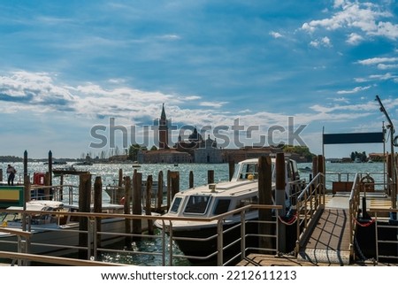 Water taxi rank on the Venice waterfront on the Grand Canal with a view of the island of San Giorgio Maggiore and blue sky in the background on a sunny morning, tourist attractions and Italy travel