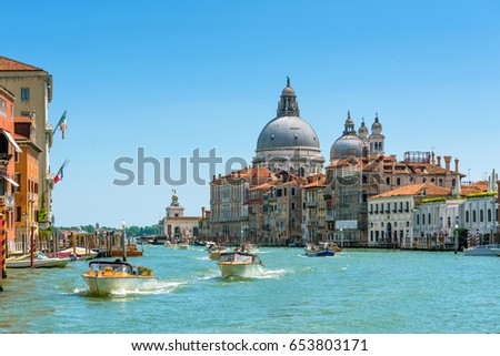 Water taxis are sailing on the Grand Canal, Venice, Italy. Sunny panoramic view of Venice with boats. Motorboats are the main transport in Venice. Panorama of the main street of Venice in summer.
