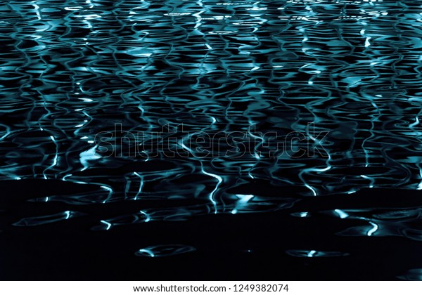 黒い背景に水のテクスチャーと色の反射 プールの水面に映る窓から青い光が当たる ネオンが光る黒い水 の写真素材 今すぐ編集