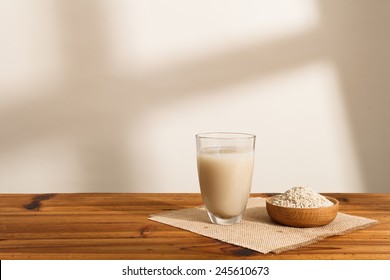 The water that clean out rice like milk in the glass,and Some rough rice in wooden bowl - Powered by Shutterstock