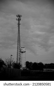 A Water Tower And A Cell Tower Standing Above A Rural Texas Town