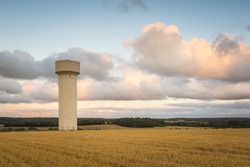 A Water Tower On Farmland In A French Landscape During Sunset.