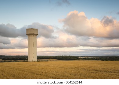 A Water Tower On Farmland In A French Landscape During Sunset.