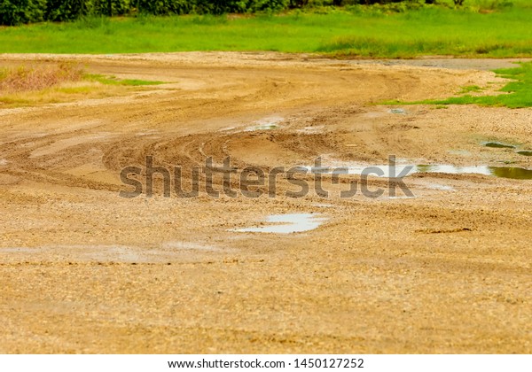 Water trapped in the hole cause of car\
wheels on the dirt road in the rainy\
season.