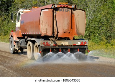 Water Truck Spraying Gravel Road to Suppress Dust and Prepare for Asphalting
