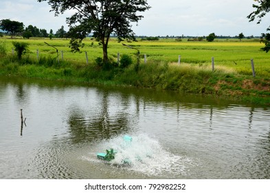 Water turbine Machine Thai Style working in natural pond beside rice field at countryside of Thailand
