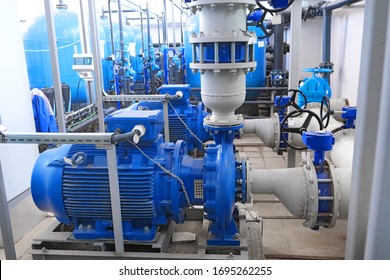 water or wastewater treatment facilities inside or indoors, blue high-pressure pumps engines and gray pipes, industrial interior