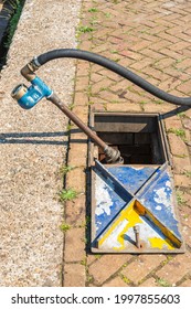 Water Well With Unscrewed Connection Where The Rubber Hose Is Connected To A Base With Water Meter