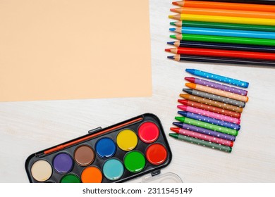 Watercolor paints, colorful pencils, pastel crayons,blank watercolor paper pad. Creativity creation process. Artist's stuff on white table.Top view Flatlay of drawing supplies. - Shutterstock ID 2311545149