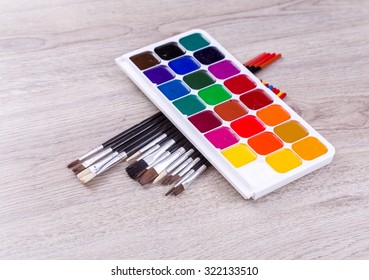 Watercolor Paints With Set Of Paint Brushes On Wooden Background