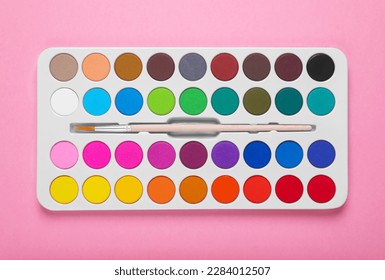 Watercolor palette with brush on pink background, top view - Powered by Shutterstock