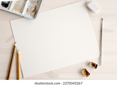 Watercolor paper blank with paint pallete and brush artist set. Aquarelle drawing canvas template with copy space and paintbrush for craft hobby - Powered by Shutterstock