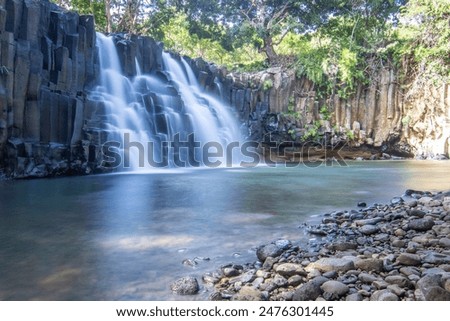 The waterfall is a 10 m high waterfall that cascades over basal steles into a pool. Tropical nature and landscape at Rochester Falls, Mauritius.