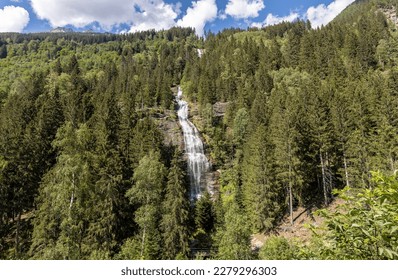 Waterfall in the Austrian Alps surrounded by green forest in summer - Shutterstock ID 2279296303