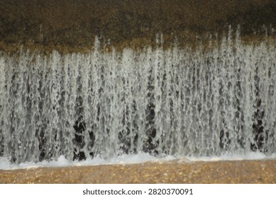 A waterfall, capturing the texture and movement of cascading water.