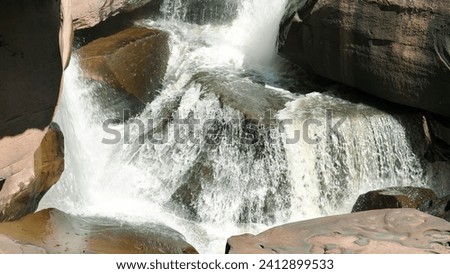 Waterfall cascade on rocks stairs. Beautiful waterfall on mountain rocks. Waterfall flowing over rocks. Waterfall stream on rocks. Beautiful nature concept